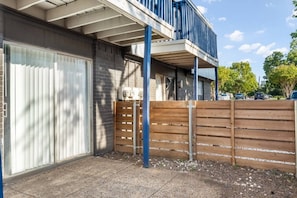 A residential building with a garage door, a wooden fence, and a balcony. - 2 Min AT&T Stadium Walk | Cozy & Clean 2BR Apt (Arlington)