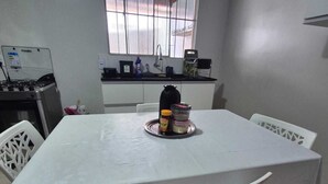 Una cocina funcional con una mesa, sillas y un ventanal.