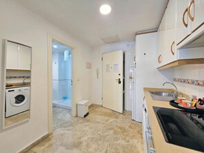 A compact kitchen with a washing machine, a refrigerator, and a sink. - Apartamento Alba 1 by Interhome (Cartagena)