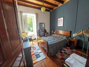 A bedroom with a bed, a desk, a chair, a wardrobe, and a window with curtains. - Pizarra by Interhome (Vilalba)