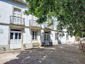 A street with white buildings, a bench, and potted plants. - Pizarra by Interhome (Vilalba)