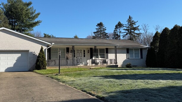 A single-story house with a garage, a covered porch, and a well-maintained lawn. - The Massillon Retreat! (Massillon)