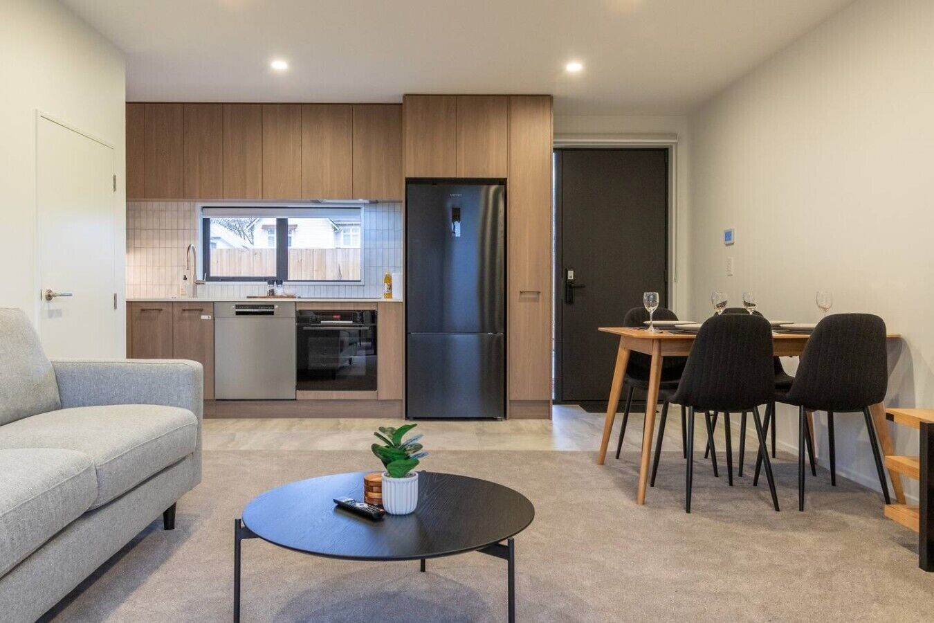 A modern apartment with a living room, kitchen, and dining area.
