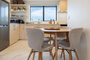 Une cuisine moderne avec une table à manger, des chaises et un réfrigérateur.