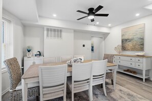 A dining area with a white table, chairs, and a ceiling fan. - North End 5BR/ 2.5BA Retreat - Walk to Beach & Boardwalk (Ocean City)