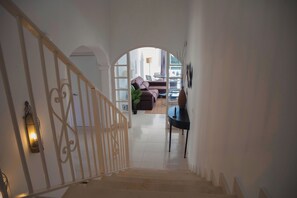 Una escalera que lleva a una sala de estar con un sofá y una mesa.