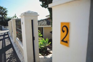 Una entrada protegida con un muro blanco y un cartel con el número 2.