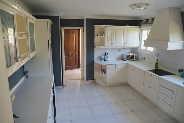 A kitchen with white cabinets, a microwave, and a sink.