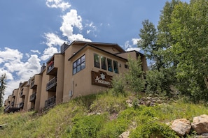 A multi-story building with a sign reading 'Angelhaus' on the side, surrounded by greenery and rocks. - Your Basecamp! Responsive host! Best deal! (Durango)