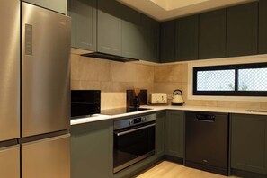 A modern kitchen with stainless steel appliances, a built-in oven, and a dishwasher.