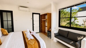 Een hotelkamer met een bed, een bank, een kledingkast en een raam met uitzicht.