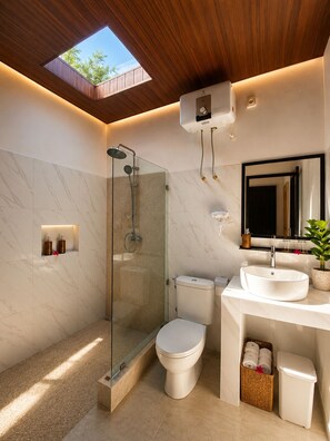 A modern bathroom with a skylight, a glass-enclosed shower, a toilet, and a sink with a mirror above it. - Penida Cabins (Penida Island)
