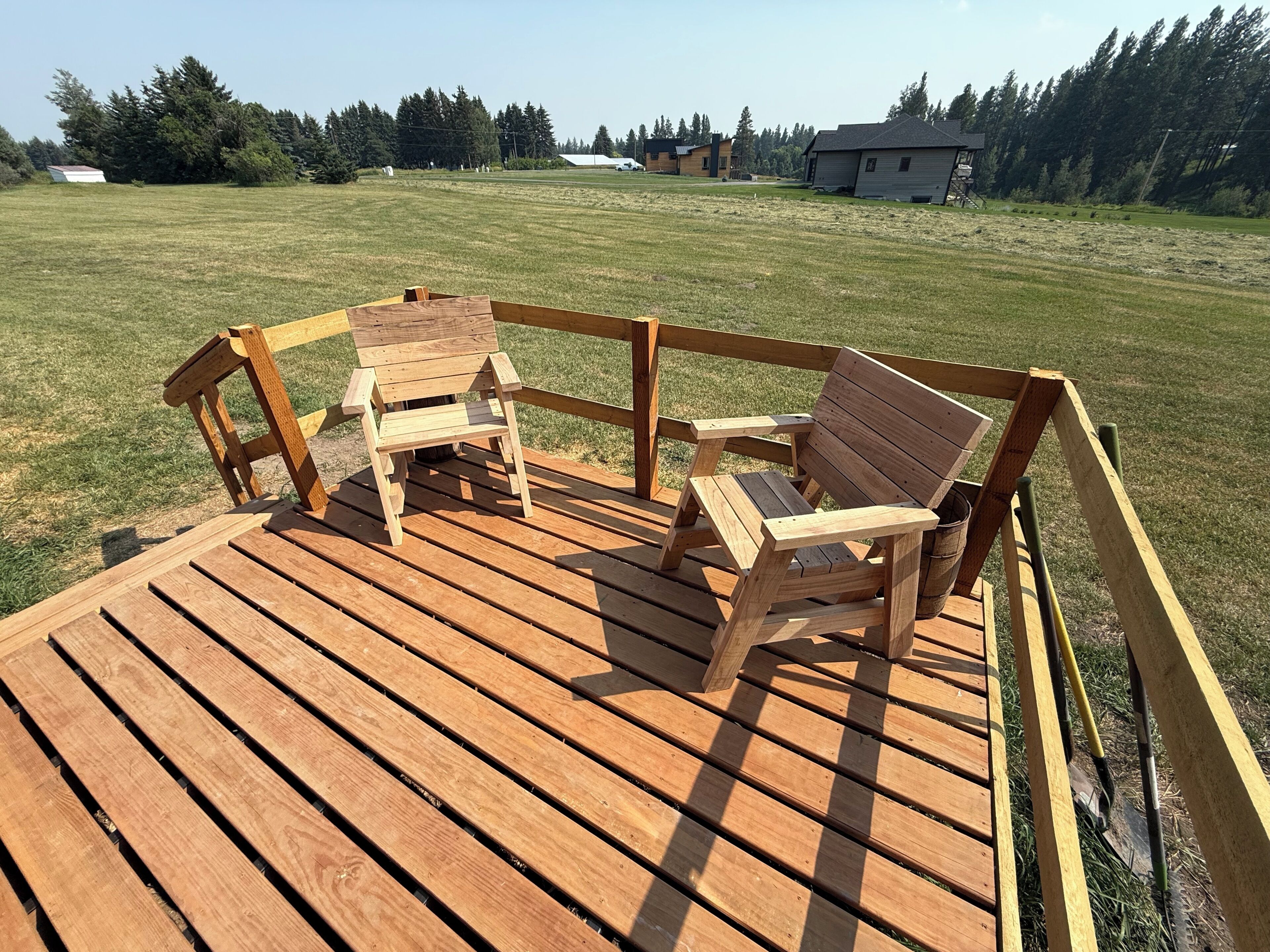 A wooden deck with two chairs and a table.