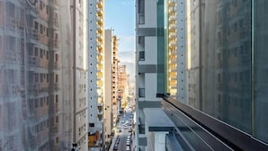 A high-rise building with multiple floors, a clear sky, and a street with cars. - Ap With sea View Near the Beach in Itapema Alx0803 (Itapema)