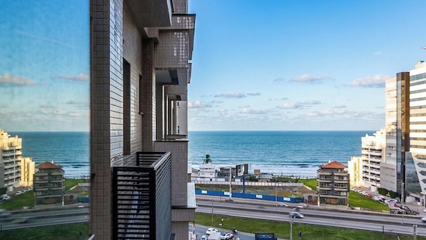 A high-rise building with a view of the sea and a highway. - Ap With sea View Near the Beach in Itapema Alx0803 (Itapema)