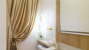A bathroom with a toilet, a sink, a mirror, and a door with a light switch. - Ap With sea View Near the Beach in Itapema Alx0803 (Itapema)