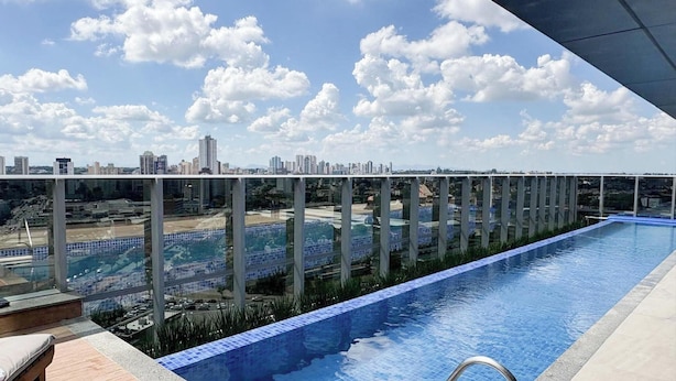 A rooftop pool with a clear view of a city skyline. - Apt. in Condo. w/ Heated Pool Sak1138 (Curitiba)