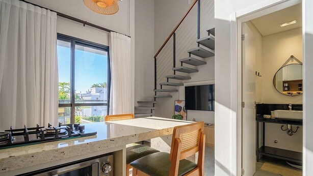 A compact kitchen with a gas stove, a dining table, and a view of the outside. - Apt. w/ Balcony in Condo. 500m From Beach Lan0204 (Florianópolis)