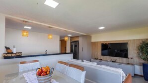 A modern kitchen with a built-in refrigerator and a dining area with a table set for two. - Ap With Jacuzzi and sea View in Ilheus, BA Cdw0102 (Ilhéus)