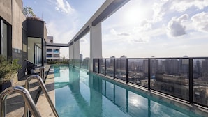A rooftop infinity pool with a city view, surrounded by glass railings and modern architecture. - Studio With Balcony in a Cond. With Pool Gyr0305 (Goiânia)