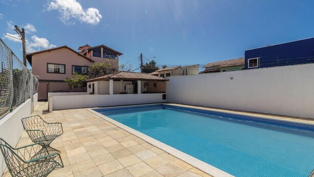 A swimming pool with tiled flooring, a small adjacent structure, and a fence. - Apart w/ Balcony in Condominium With Pool Vdp0000 (Cabo Frio)