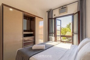 Ein Schlafzimmer mit Bett, Kleiderschrank und Fenster mit Blick.