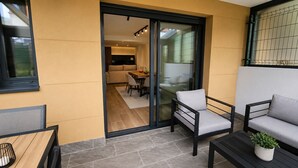 A modern outdoor seating area with a sliding glass door leading to a kitchen. - Villa Carinn Sella - Ribadesella - Beach 2 km away (Ribadesella)