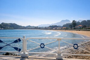 A coastal view with a clear sky, a sandy beach, and a mountain range in the distance. - Villa Carinn Sella - Ribadesella - Beach 2 km away (Ribadesella)