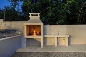 A concrete outdoor kitchen with a built-in fire pit and a sink. - Villa Mochi (Istria - Pićan) (Pićan)