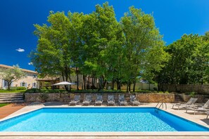 A swimming pool with lounge chairs and a stone wall. - Villa Roveria (Istria - Butkovići) (Butkovići)