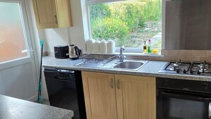 A modern kitchen with a built-in stove, a sink, and wooden cabinets.
