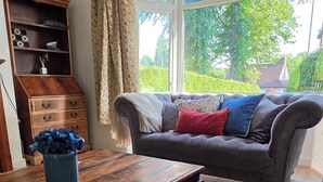 A living room with a sofa, a wooden coffee table, and a bookshelf.