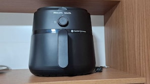 Ein schwarzer Philips Walita Heißluftfritteuse auf einem Holzregal.