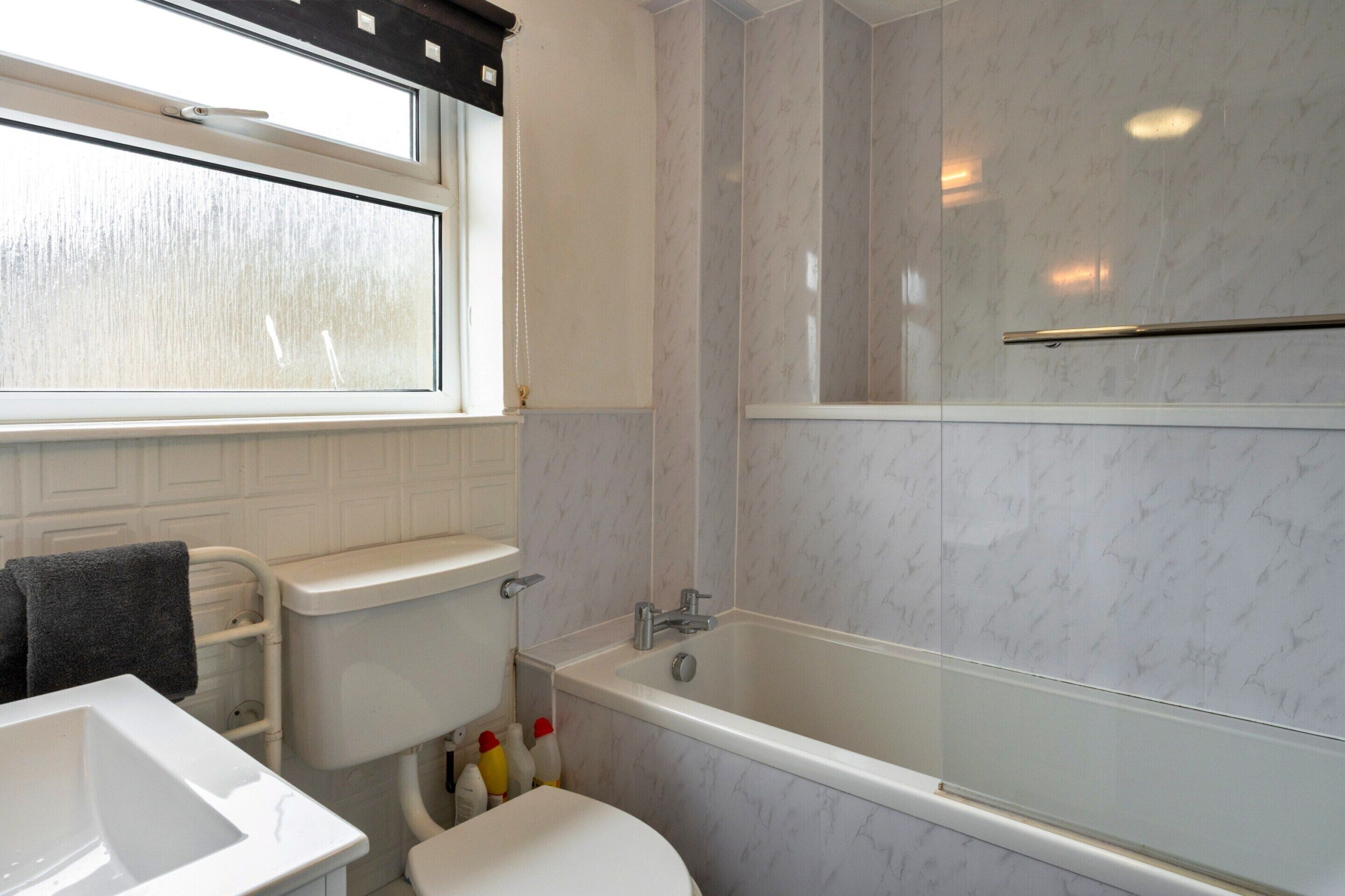 A bathroom with a toilet, sink, and bathtub.