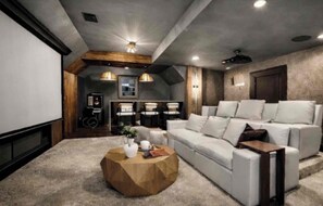 Un salon moderne avec un grand canapé blanc, une table basse et un ventilateur de plafond.