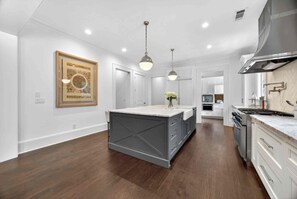A modern kitchen with a central island, white cabinetry, and pendant lighting. - Luxury Estate With Resort Style Pool/4BR/7Bath/Car rental/concierge upon request (Atlanta)