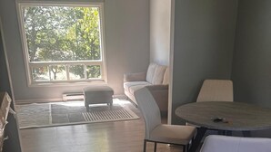 Une pièce comprenant une table ronde, deux chaises, un banc et un canapé.