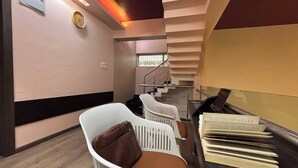 A hotel lobby with a staircase, a clock, and a reception desk.