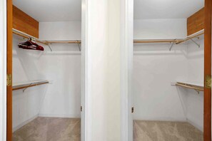 Un dressing avec des étagères en bois et une tringle pour suspendre les vêtements.