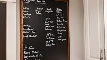 Un tableau noir sur lequel figure une liste de suggestions pour les meilleurs endroits où prendre un café, déjeuner, dîner, boire un verre, faire ses courses et profiter de la nature.
