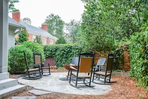 A patio with outdoor furniture, a stone floor, and a brick wall.