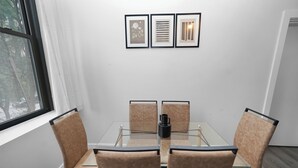 A conference room with a glass table, cushioned chairs, and framed artwork on the wall. - Cozy 2BR Near McCormick & Wintrust with Optional Parking (Chicago)