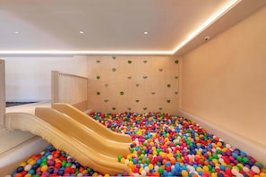 Ein Spielbereich mit zwei Rutschen und einem Ballbecken voller bunter Bälle.