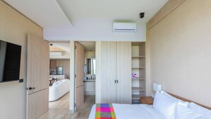 Ein modernes Hotelzimmer mit Bett, Fernseher, Küchenzeile und Badezimmer.