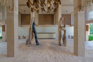 A spacious lobby with a high ceiling, large columns, and a central sculpture. - Bright 2BR Retreat near Golf & Beach (Playa del Carmen)