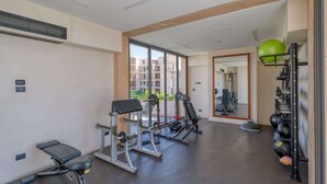 Ett gym med träningsredskap, en bänk och en vägg med speglar.