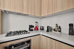 A modern kitchen with a gas stove, a coffee maker, a blender, a toaster, and a knife block. - 1BR Retreat in Corasol, Playa del Carmen (Playa del Carmen)