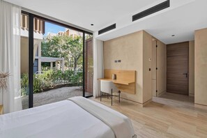 Une chambre moderne avec un grand lit, un bureau et une porte coulissante donnant sur un balcon.