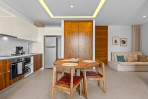 Eine moderne Küche mit Essbereich, Holzschränken und einem eingebauten Backofen.