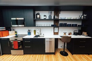 A modern kitchen with black cabinets, a white countertop, and stainless steel appliances. - Loft 306 - The WIlliam - Atrium - Downtown Vibes (Birmingham)